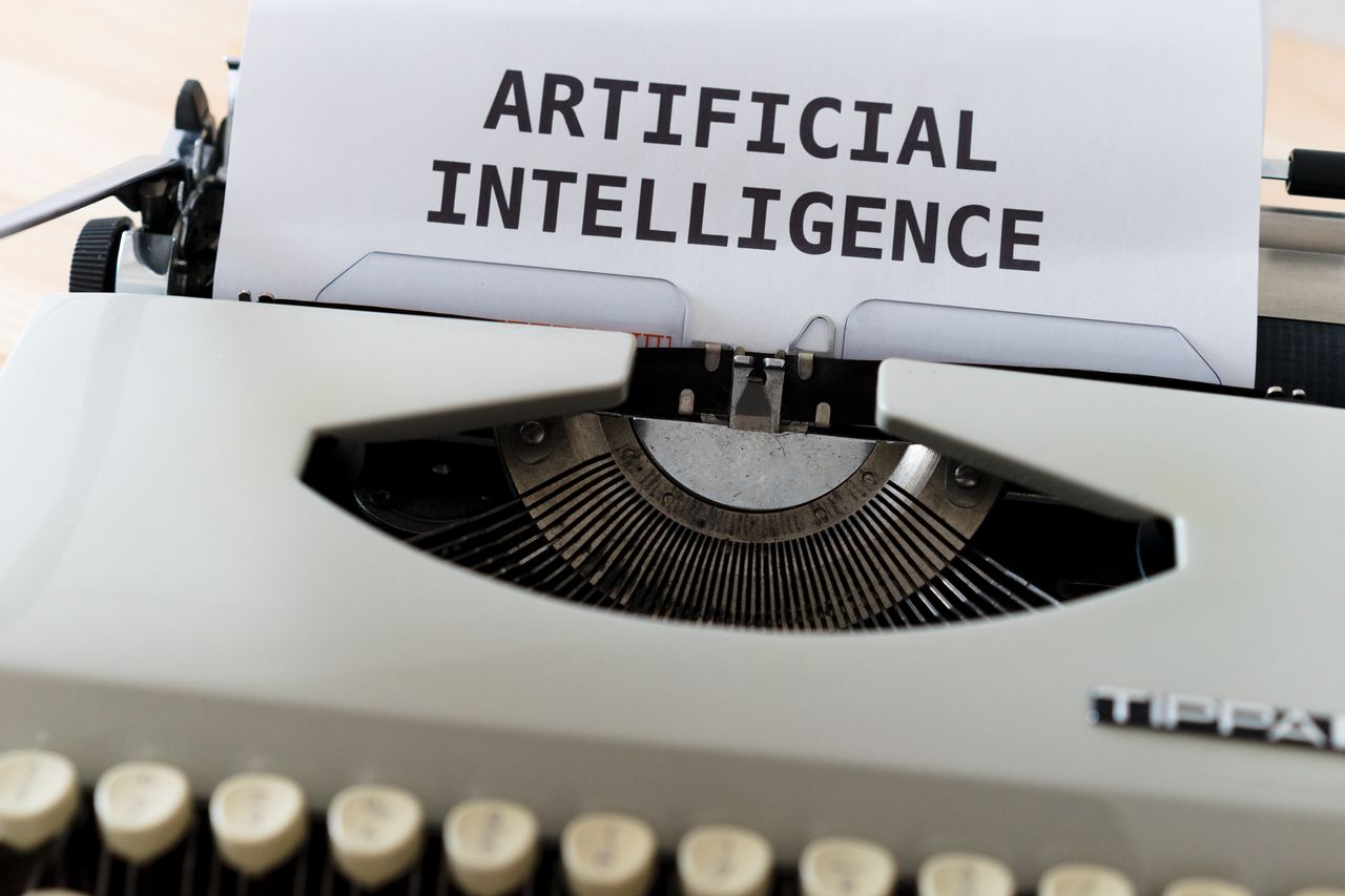 A close-up of a typewriter showcasing ARTIFICIAL INTELLIGENCE on paper.